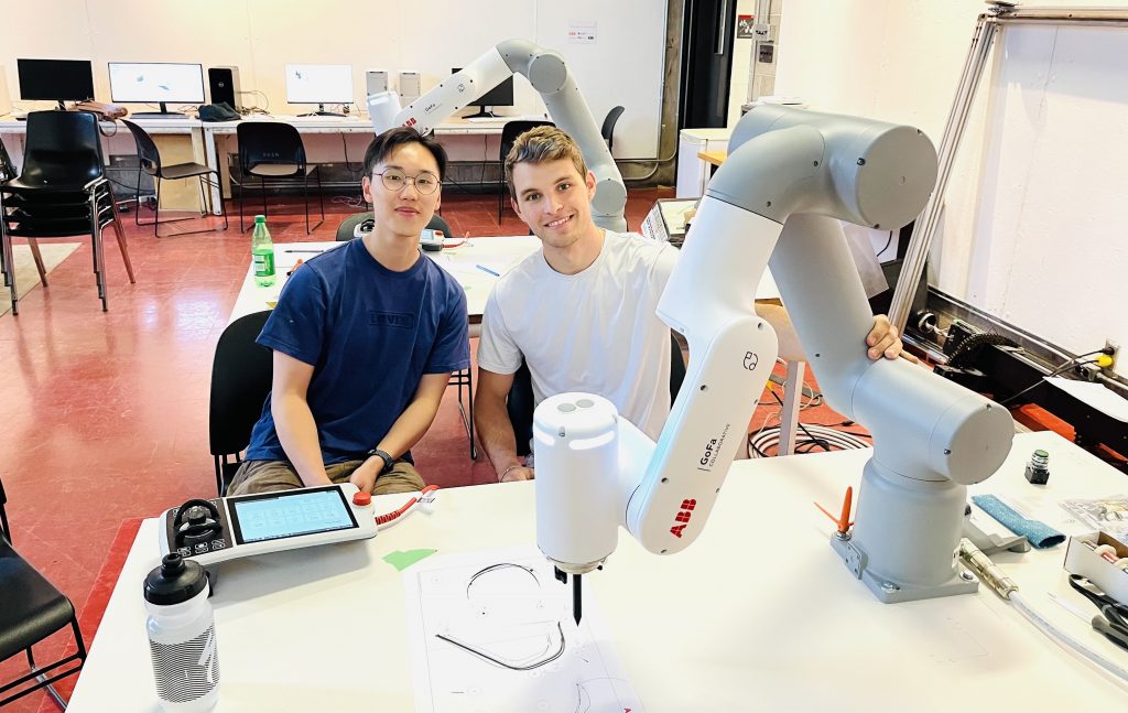 Two students with robotics arm