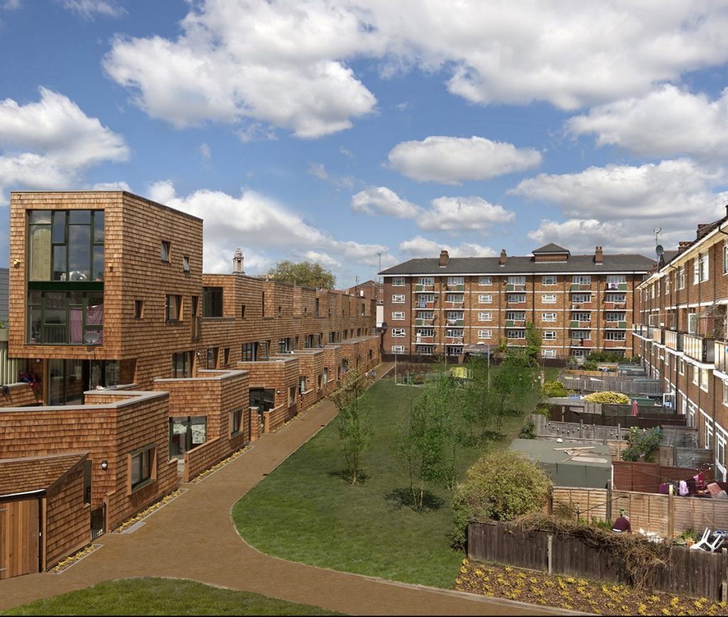 Image of a garden, surrounded by brown buildings on three sides