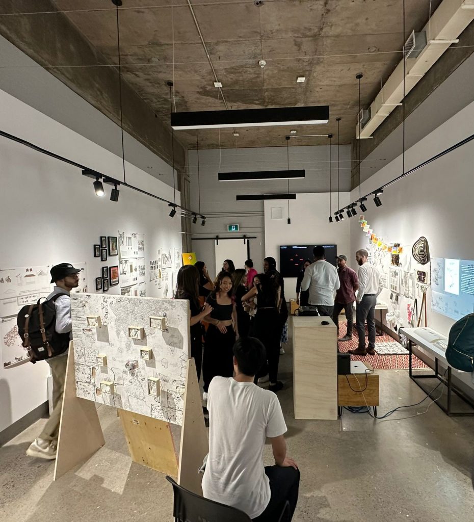 A photo capturing a group of students gathered in the exhibition room, surrounded by works on display.