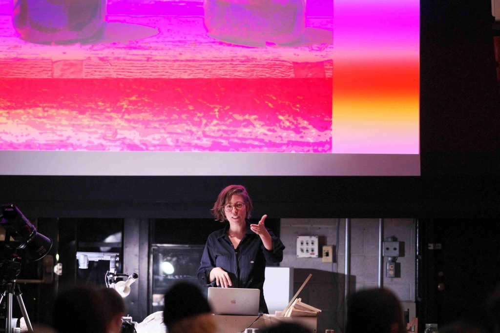 A woman giving a presentation in front of a projection screen. A woman giving a presentation in front of a projection screen.