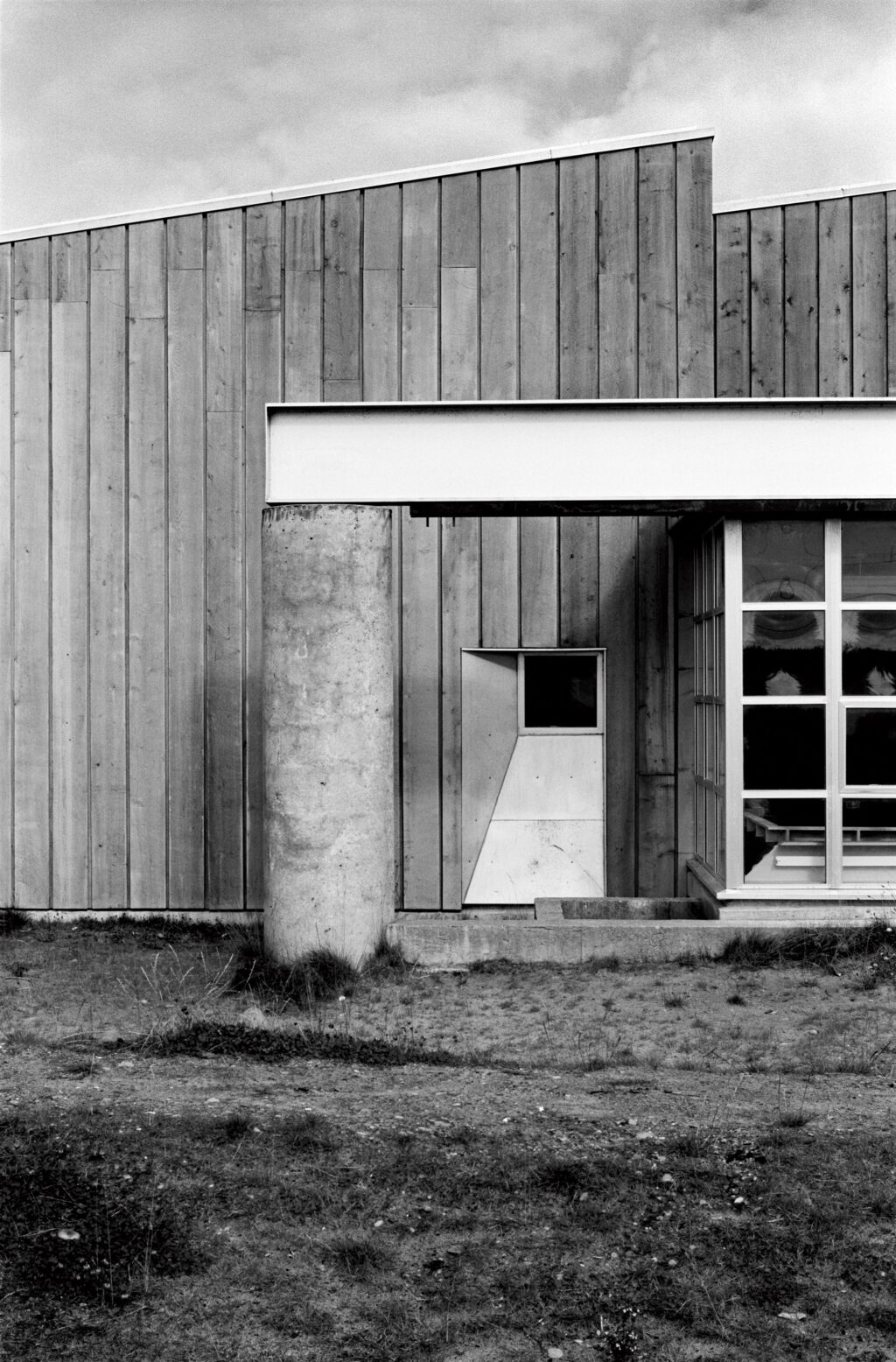 Chief Matthews School facade with post and beam structure and vertical wood siding.