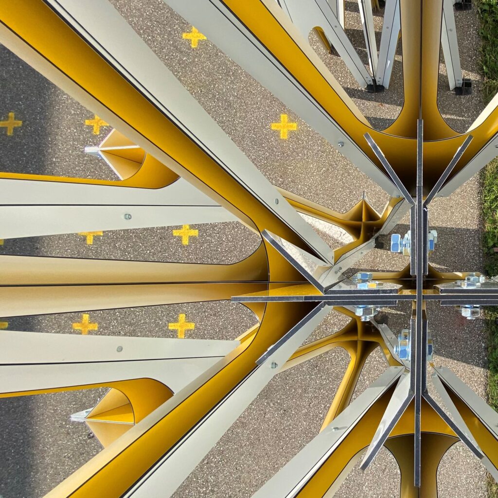 Close-up of a mirrored yellow and white metal structure with bolts