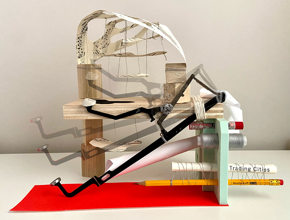 A mixed-media architectural model made of wood blocks, thread, paper, and other objects