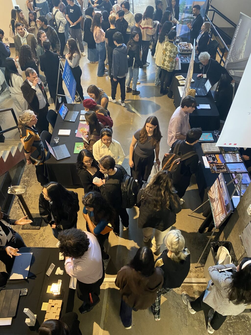 Crowd of students interacting with employers at booth tables