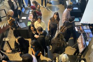 Crowd of students interacting with employers at booth tables