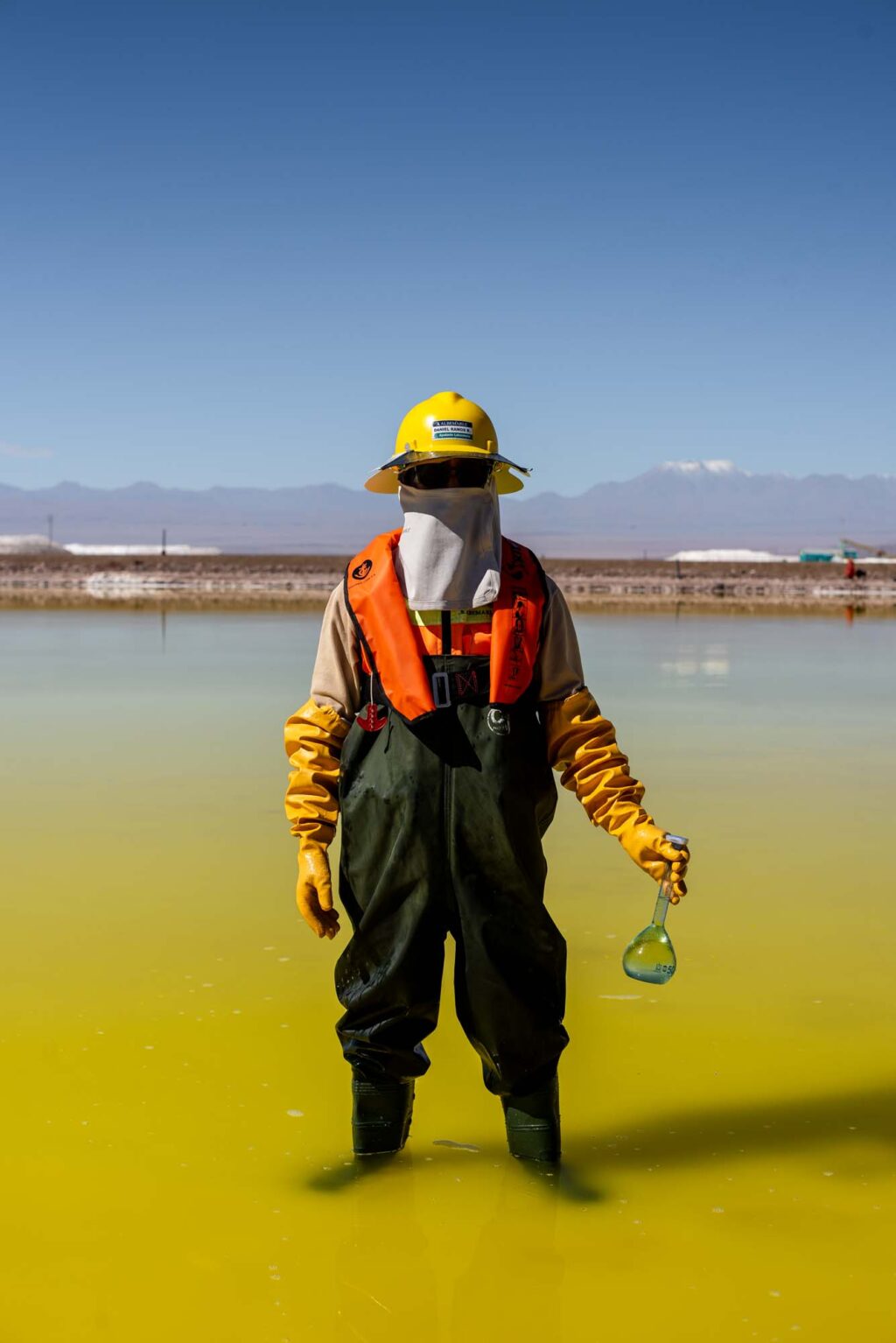 An Indigenous water protector collects samples from a lithium brine pool in the Andean Salt Flats near the Atacama Desert.