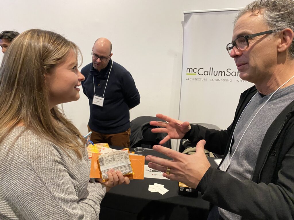 Two representatives from mcCallumSather engage in conversation with a student.