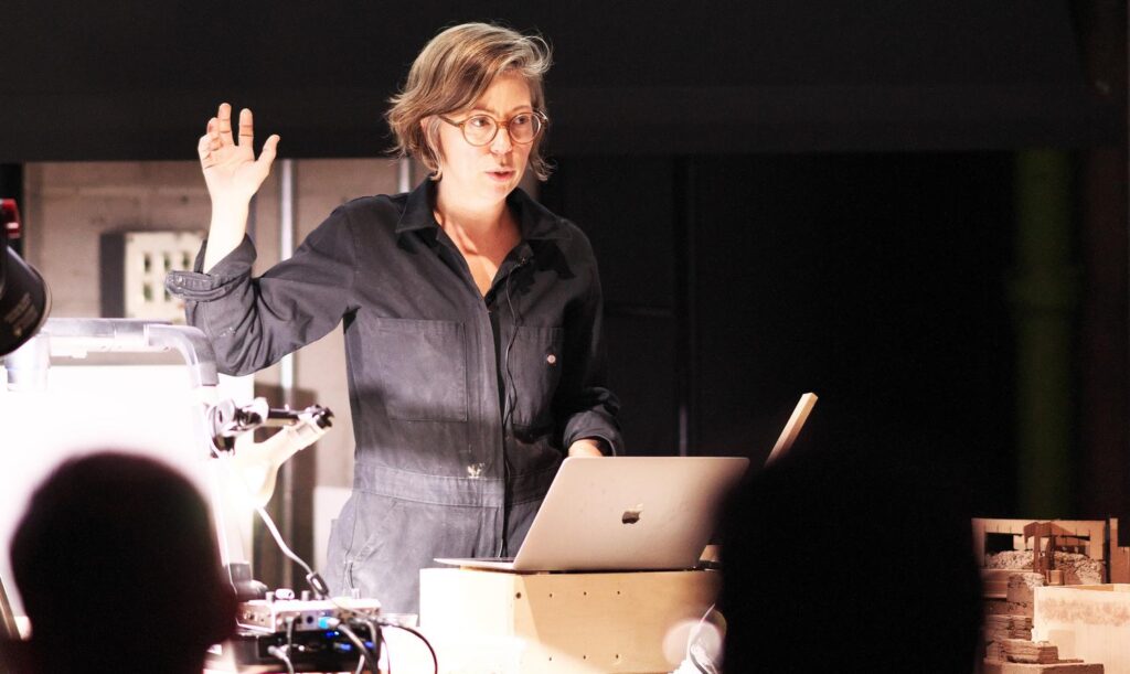 Lisa Moffitt presenting at a podium with a laptop