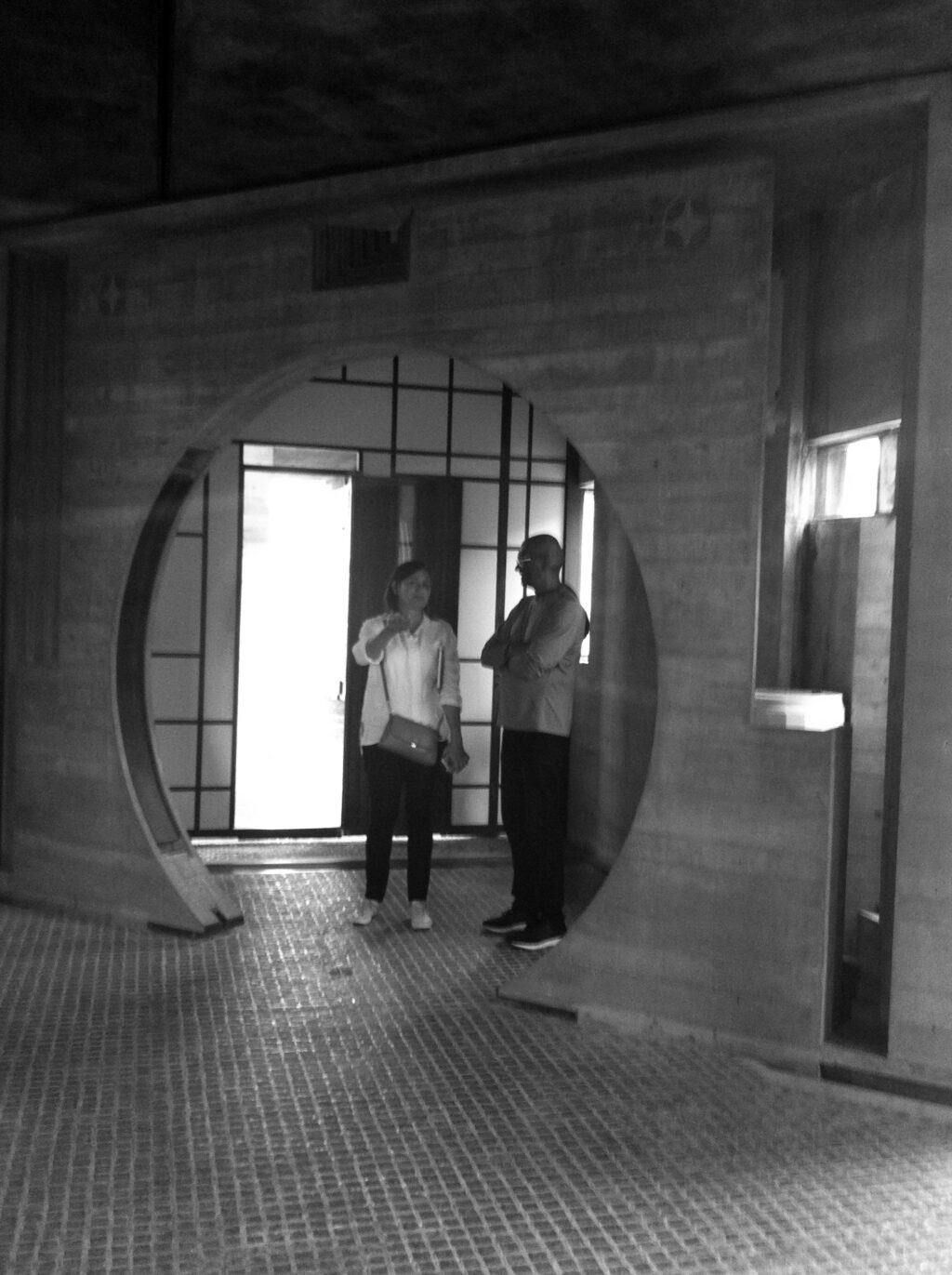 Two people standing beneath a circular concrete opening