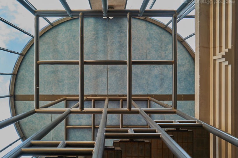 Upward view of a glass and steel ceiling structure, showing Scarpa’s layered framing and material detailing.