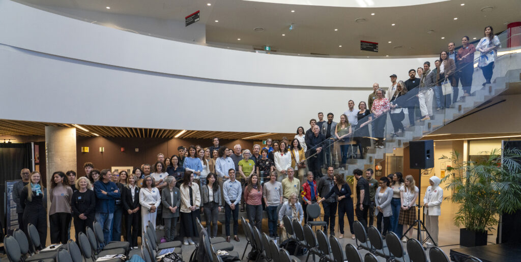 Conference attendees stading on the stairs in the Nicol Building lobby.