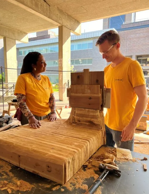 2 students working on a wood structure for the Action Lab
